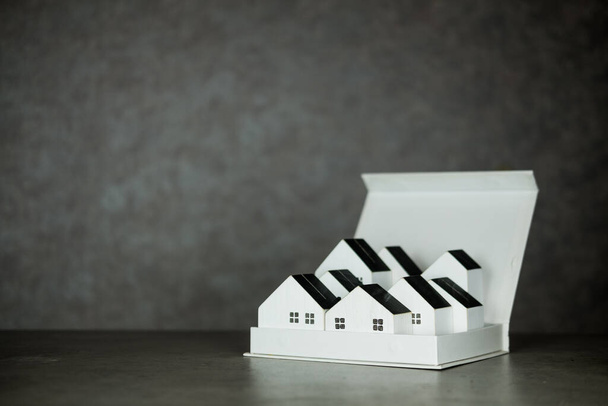 Farklı boyutlarda küçük ahşap ev modelleriyle dolu bir kutu. Yeni ev satma konsepti - Fotoğraf, Görsel