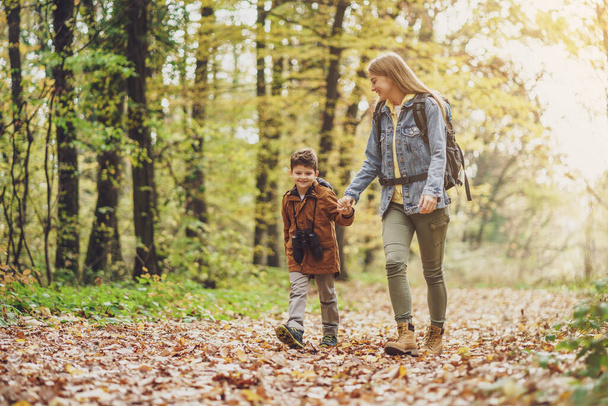 Happy mother and son are hiking in forest. - Foto, imagen