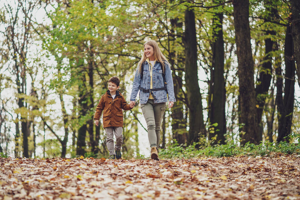 Mãe e filho felizes estão caminhando na floresta. - Foto, Imagem