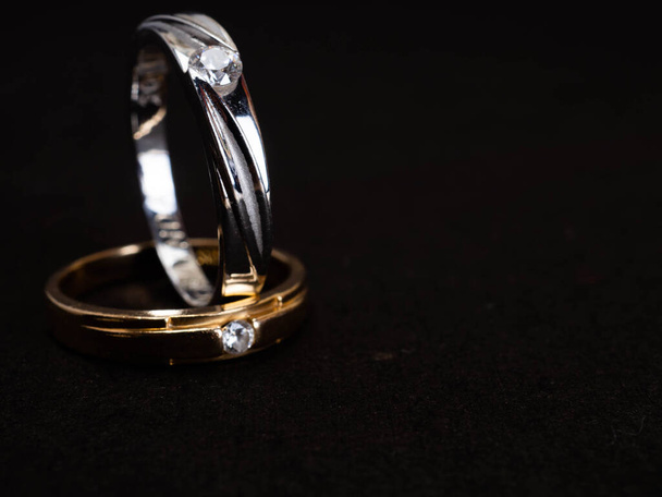 Close up sparare di anello di nozze in oro con bel diamante su uno sfondo nero - Foto, immagini
