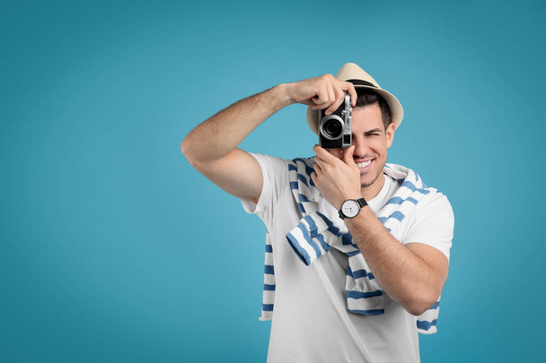 Male tourist taking picture on turquoise background, space for text - Fotografie, Obrázek