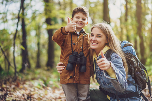 Happy mother and son are hiking in forest. - Foto, Imagen