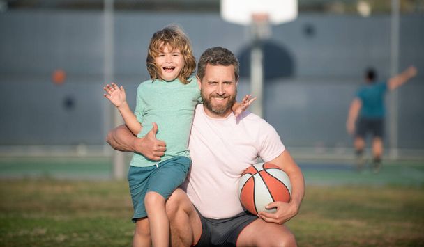 Счастливого дня отца. семейный портрет. Папа и малыш держат спортивный мяч. детский баскетбол. - Фото, изображение