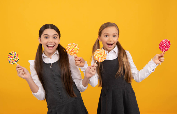 amazed teen girl in school uniform hold lollipop sweets, childhood - Foto, Imagen