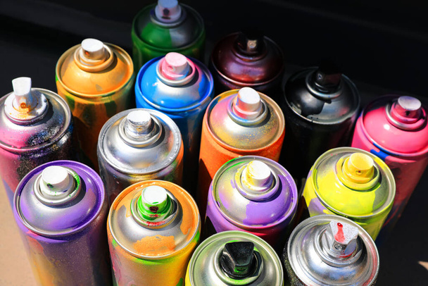 Many different used cans of spray paint, above view. Graffiti supplies - Zdjęcie, obraz