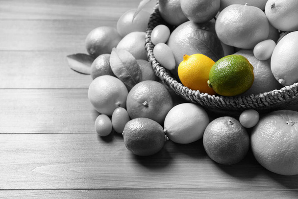 Different citrus fruits on wooden table. Black and white tone with selective color effect - Foto, immagini