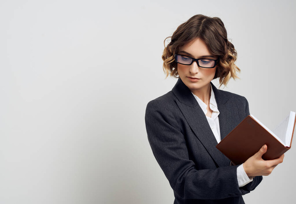 γυναίκα με κοστούμι επιχειρηματία με ένα βιβλίο στα χέρια του εκτελεστικό γραφείο - Φωτογραφία, εικόνα