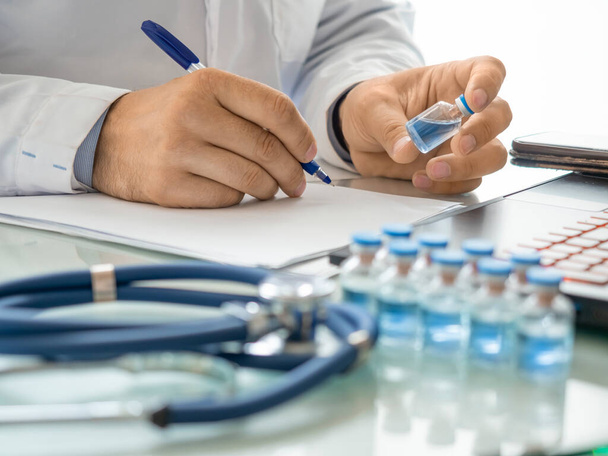 Visão de perto de um médico mãos segurando um tubo de teste com vacina moderna. - Foto, Imagem