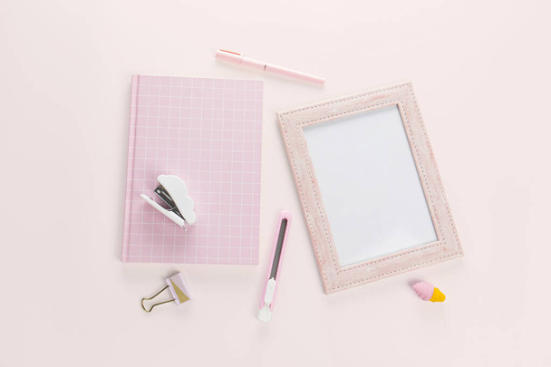 plat lag roze boek en briefpapier op roze pastel achtergrond - Foto, afbeelding