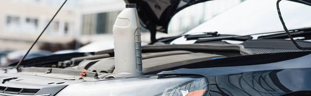 Bottiglia di olio motore su auto con cappuccio aperto, banner  - Foto, immagini