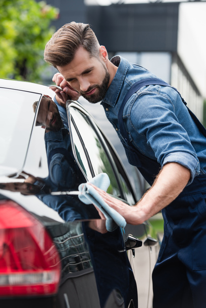 Mechanic waxing car on blurred foreground outdoors  - Photo, Image