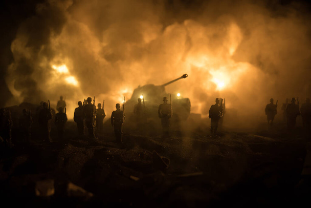 Έννοια πολέμου. Στρατιωτικές σιλουέτες καταπολέμηση σκηνή στο φόντο ομίχλη του πολέμου ουρανό, Στρατιώτες του Παγκοσμίου Πολέμου Σιλουέτα κάτω από συννεφιά Skyline τη νύχτα. Θωρακισμένο όχημα σκηνή αγώνα. Επιλεκτική εστίαση - Φωτογραφία, εικόνα