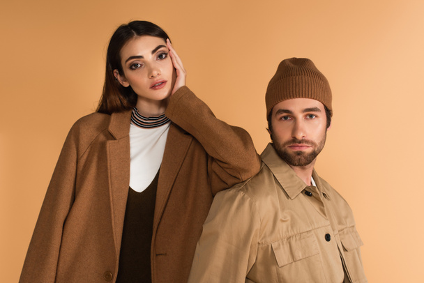 young couple in stylish autumn outfit looking at camera isolated on beige - Foto, Bild