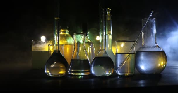 Φαρμακευτική και χημεία θέμα. Γυάλινη φιάλη δοκιμής με διάλυμα σε ερευνητικό εργαστήριο. Επιστήμη και ιατρικό υπόβαθρο. Εργαστηριακοί δοκιμαστικοί σωλήνες σε σκούρο τονισμένο φόντο, έννοια επιστημονικού ερευνητικού εξοπλισμού - Πλάνα, βίντεο