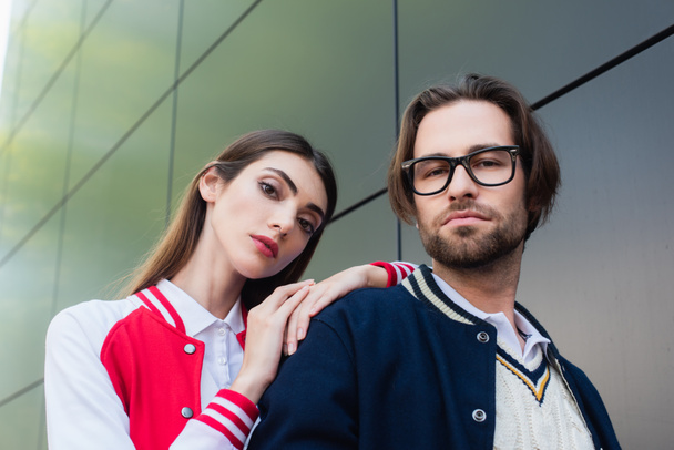 young woman leaning on shoulder of man in eyeglasses outdoors - Valokuva, kuva