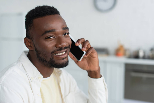 cheerful african american man talking on smartphone - Fotó, kép