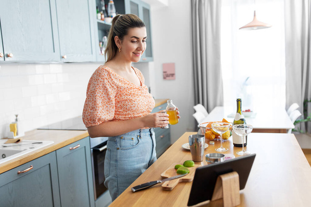 жінка з планшетним ПК робить коктейлі на кухні
 - Фото, зображення