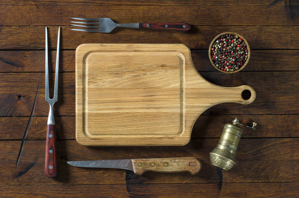 Kitchen utensils and spices for barbecue on old wood table with copy space for your text. Top view. Flat lay. - Zdjęcie, obraz