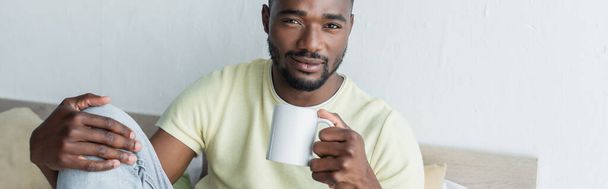 african american man holding mug with coffee, banner - Foto, Imagem