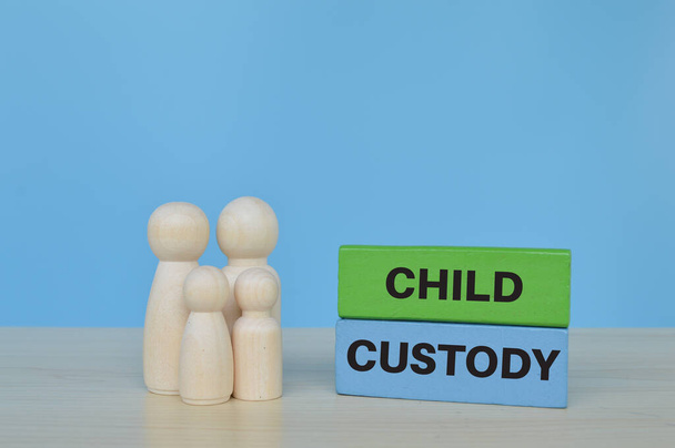 Figuras de muñecas de madera de pie sobre bloques de madera con frase CHILD CUSTODY - Foto, Imagen