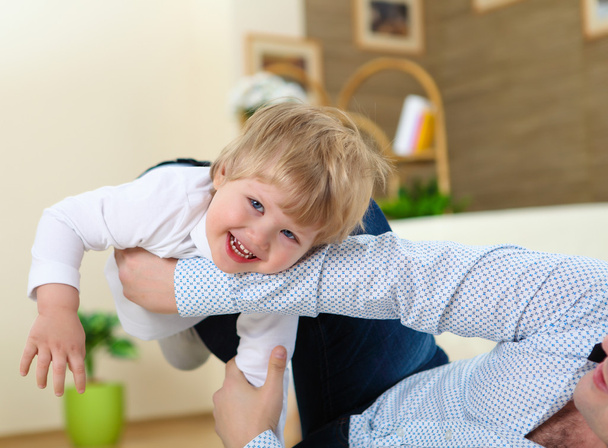 Little boy and his father playing together at home on the floor - Фото, зображення