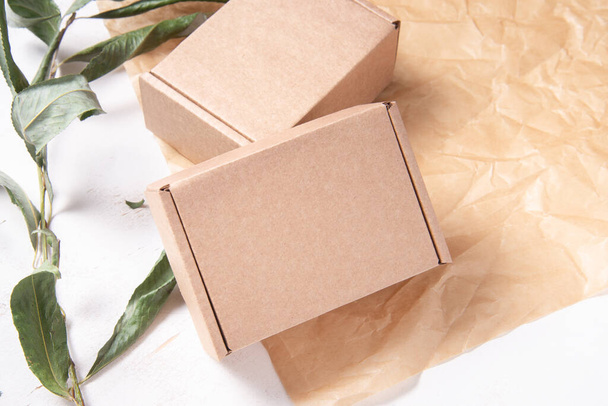 Brown Cardboard Carton box on fresh green leaves - Foto, Imagem