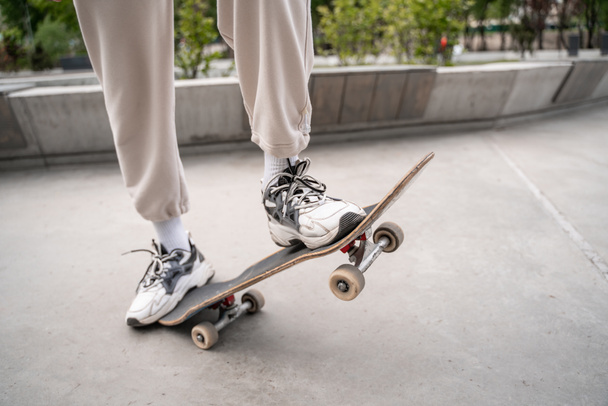 vista parcial del hombre en zapatillas patinaje al aire libre - Foto, Imagen