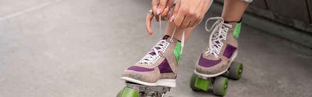 vue partielle de la femme attachant des lacets sur patins à roulettes, bannière - Photo, image