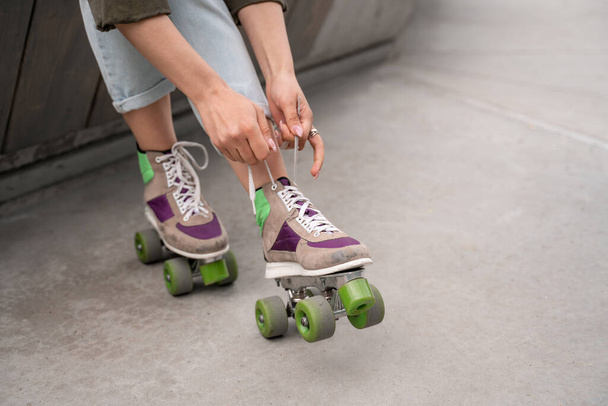 partial view of woman tying laces on roller skate outdoors - Foto, Imagem