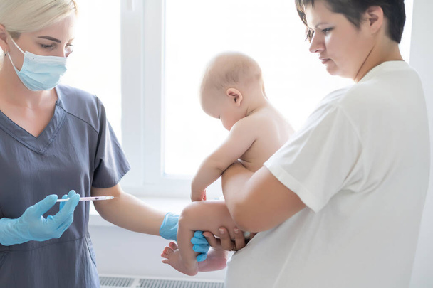 Педиатр делает прививку маленькому мальчику - Фото, изображение