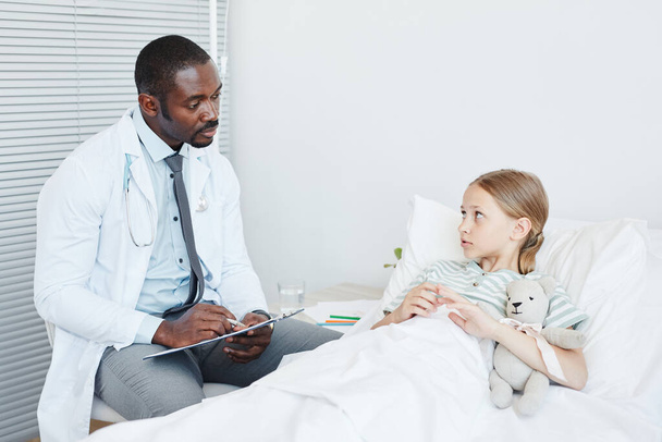 Médico hablando con un niño en el hospital - Foto, Imagen