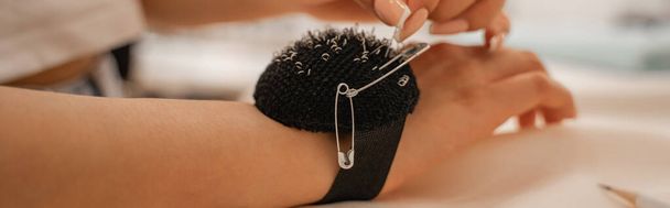 Cropped view of designer with pincushion and needles, banner  - Photo, Image