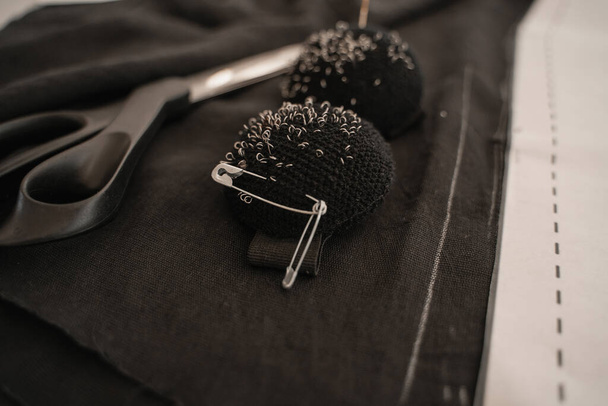 Close up view of pincushions near sewing scissors and cloth - Fotoğraf, Görsel