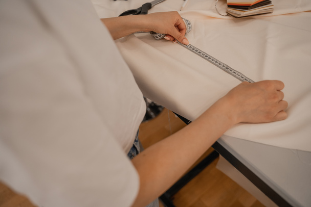 Cropped view of designer measuring cloth in studio  - Photo, Image