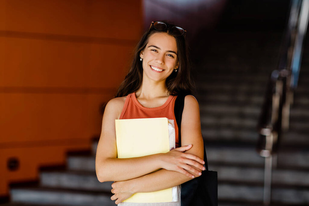 Πορτρέτο ενός χαμογελαστού κοριτσιού με ένα φάκελο στα χέρια της - Φωτογραφία, εικόνα