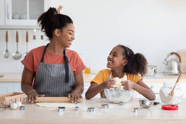 Iloinen afrikkalainen amerikkalainen äiti ja tytär leipoo yhdessä - Valokuva, kuva