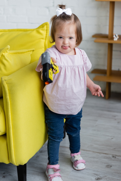 dítě s Downovým syndromem hrát si s rozmazanou hračkou zbraň - Fotografie, Obrázek