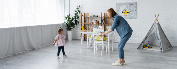 kindergarten teacher with outstretched hands standing near kid with down syndrome, banner - Fotografie, Obrázek