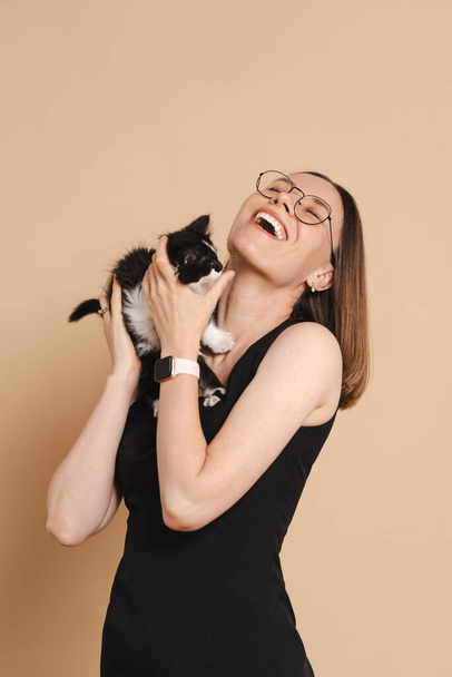 ευτυχισμένη γυναίκα πορτρέτο με γάτα σε μπεζ φόντο - Φωτογραφία, εικόνα