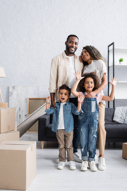 african american kids waving hands near happy parents in new apartment - Photo, Image