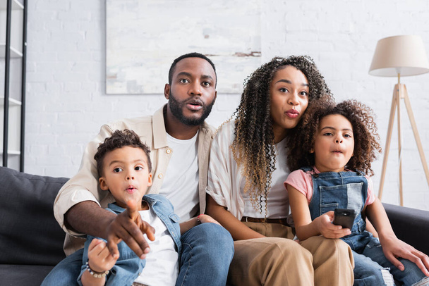 focused african american family watching movie at home - Foto, Imagem