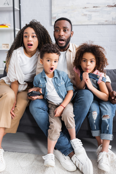 astonished african american family watching tv together at home - Фото, зображення