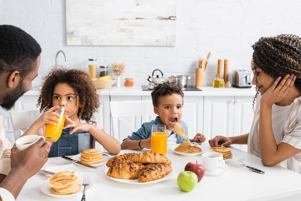 Αφροαμερικανικά παιδιά που παίρνουν πρωινό με γονείς στην κουζίνα - Φωτογραφία, εικόνα