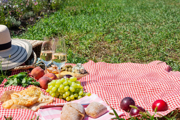 Nyári piknik a parkban a füvön. Bor, gyümölcs és croissant - Fotó, kép