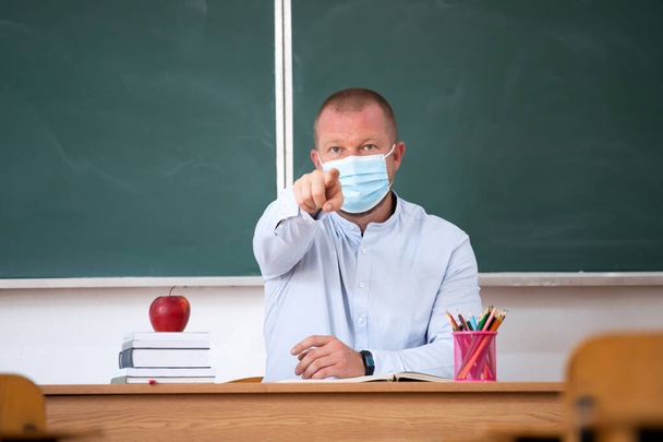  Teacher with mask in the classroom. Social distanting and classroom safety during coronavirus epidemic - Φωτογραφία, εικόνα