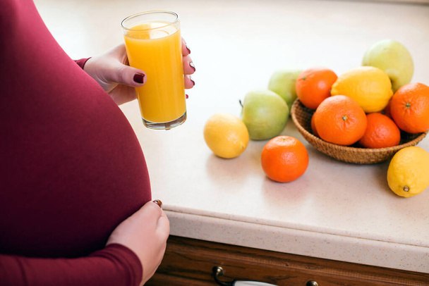 Mulher grávida na cozinha com comida saudável. Nutrição saudável e dieta durante a gravidez. Mulher grávida nova bonito com vidro de suco fresco. - Foto, Imagem