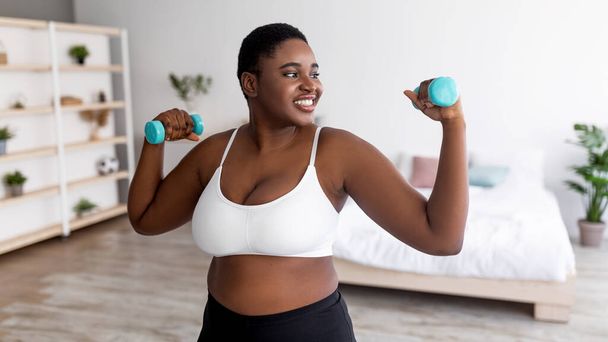 Además de tamaño joven dama negra haciendo ejercicio con pesas en casa durante el bloqueo covid, diseño de pancartas - Foto, Imagen