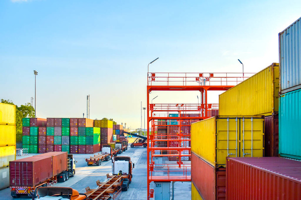 Wysoki kąt widzenia pracy stoczni kontenerowej, ciężki sprzęt dotrzeć układania kontenera do ciężarówki i przyczepy. Wysyłka kontenerowa, logistyka, transport i łańcuch dostaw. - Zdjęcie, obraz