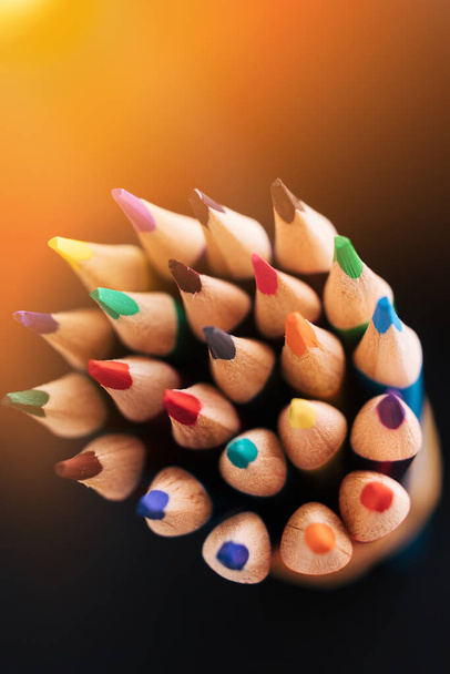 Новий колір загострених олівців на темному тлі з сонячним світлом або освітленням. Абстрактний фон на творчій темі
. - Фото, зображення