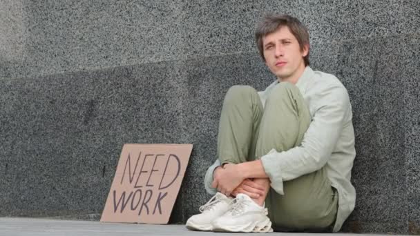 Нещасливий професійний кавказький фахівець, звільнений з роботи, сидить на вулиці з необхідною роботою. Самотній хлопець втратив роботу і чекав на пропозиції. Безробіття вінцева пандемія - Кадри, відео